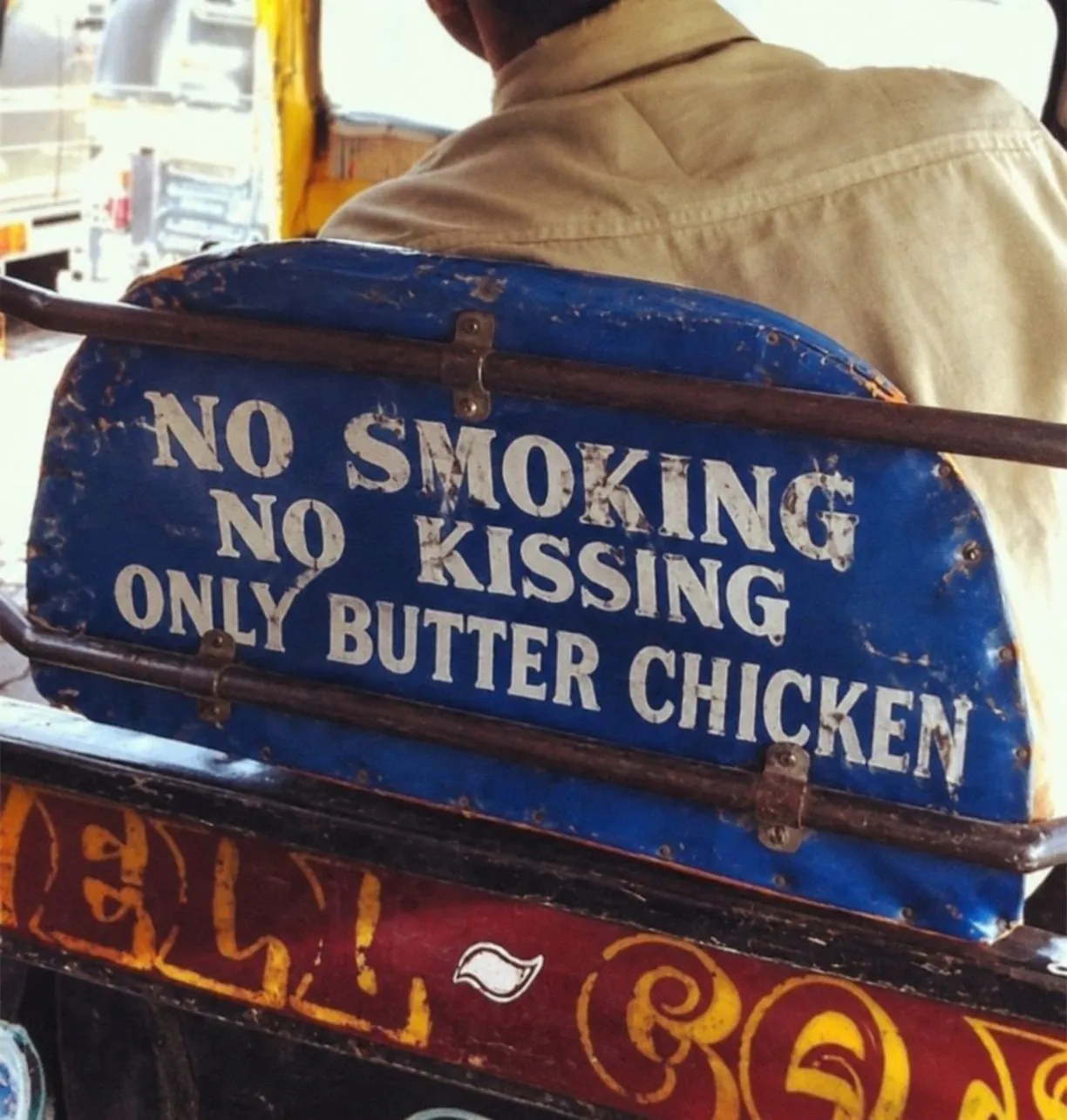 Painted blue tuk-tuk seat: No smoking. No kissing. Only butter chicken.